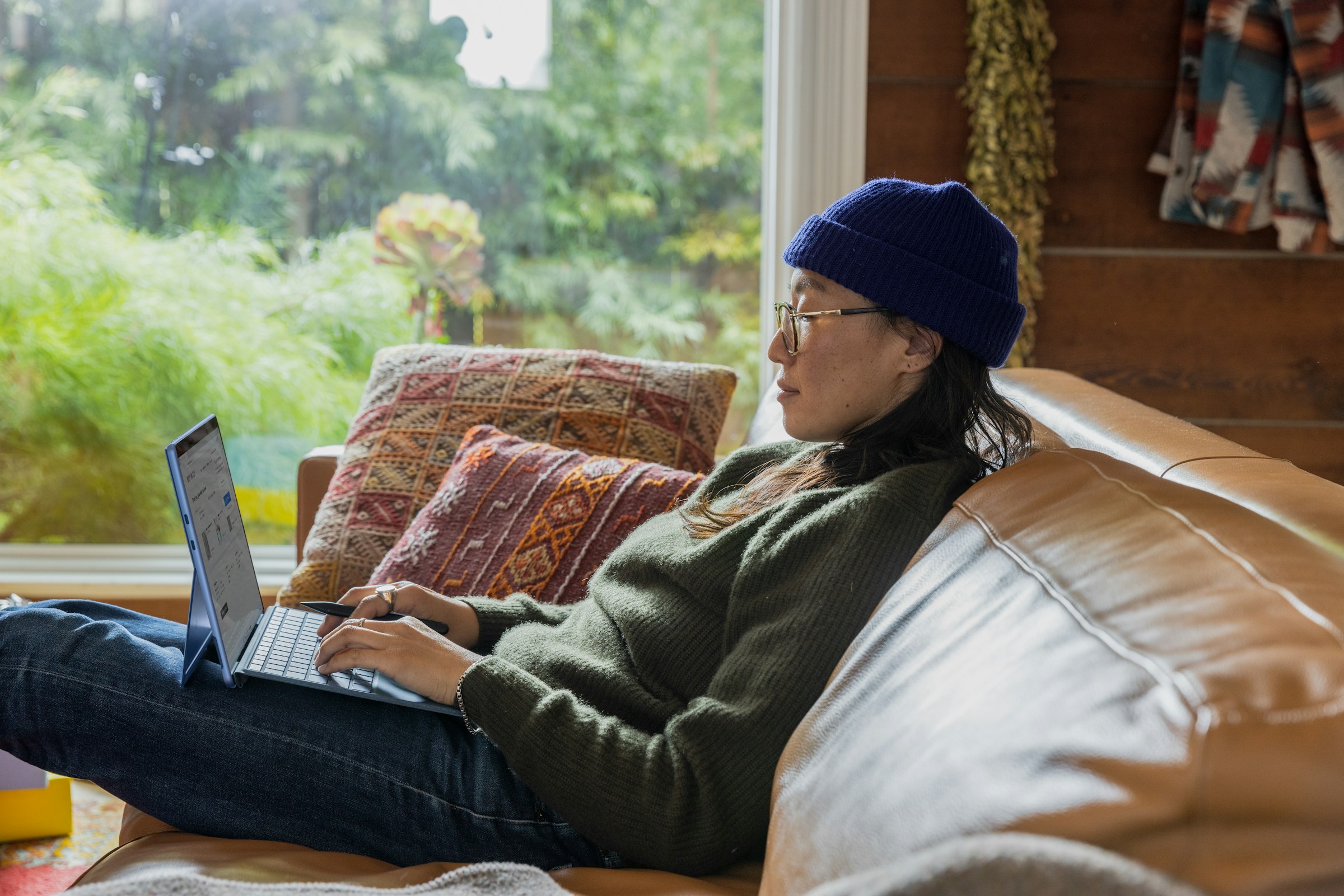 a person sitting on a couch using a laptop